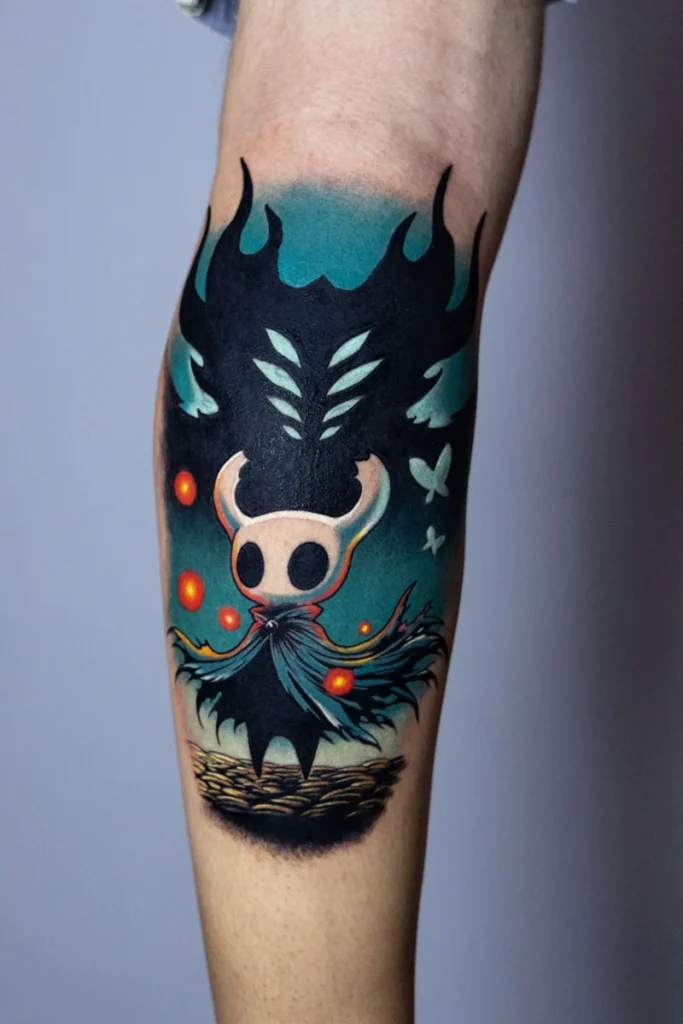 Detalle del tatuaje de Hollow Knight: orbes naranjas, polillas y la capa del Caballero a color, por Nelson