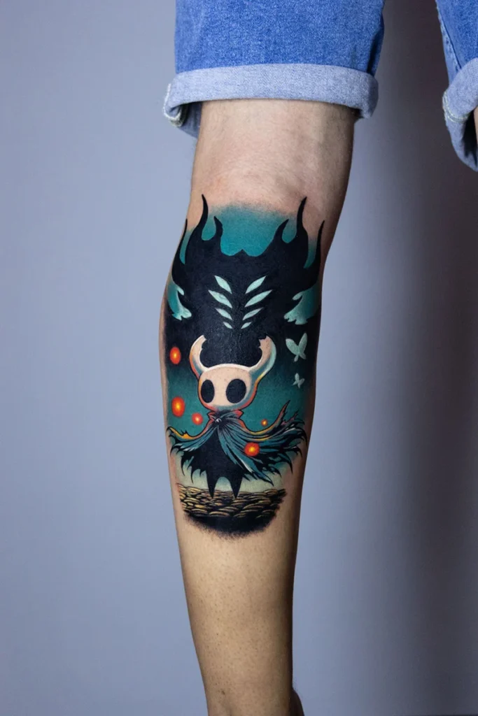 Vista lateral del tatuaje neotradicional de Hollow Knight bajo la rodilla, cover up de Nelson en Museum Tattoo